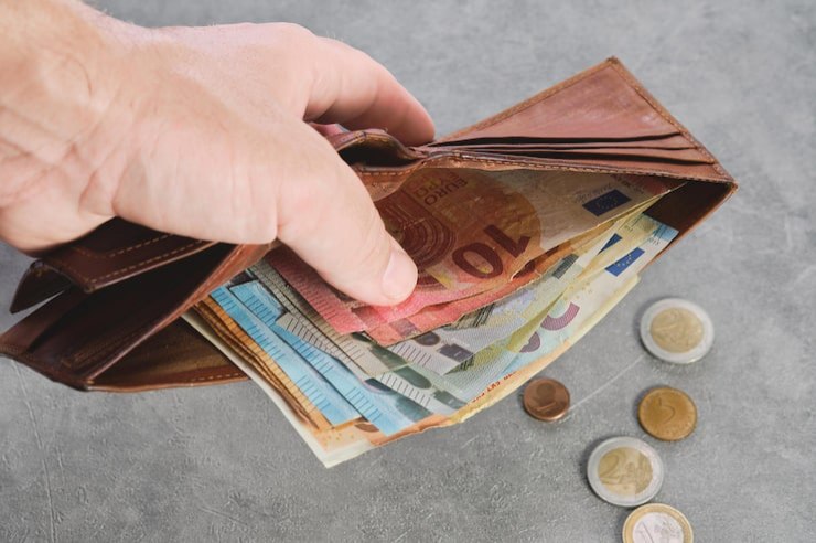 Persona con portafoglio e soldi euro
