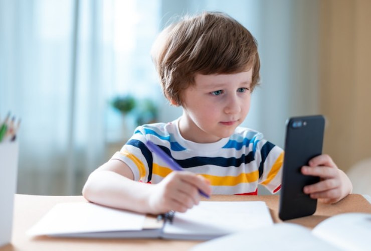 Bimbo che studia con cellulare