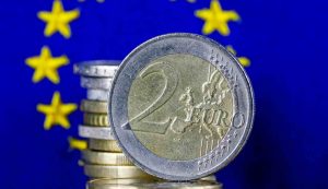 Moneta da 2 euro davanti alla bandiera europea