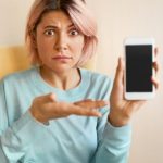 Giovane donna con cellulare in mano