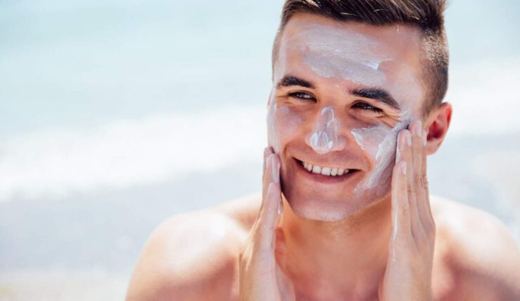 Uomo che mette la crema solare