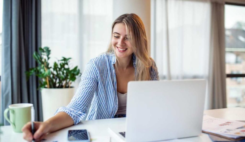 Donna felice con documenti e PC